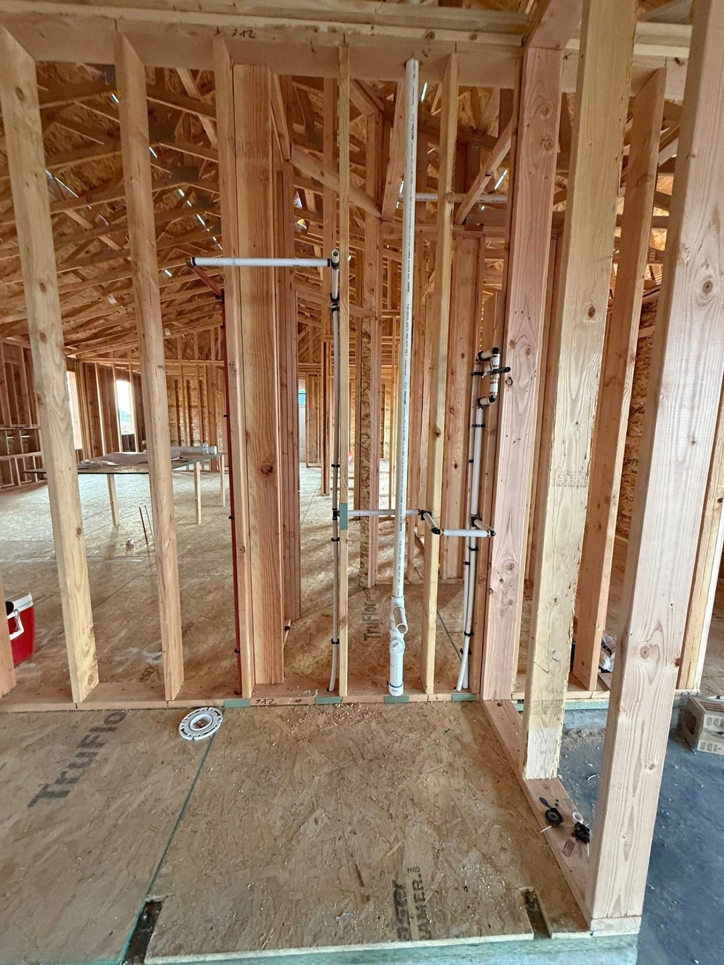 New construction rough-in framing with PEX and DWV plumbing stack